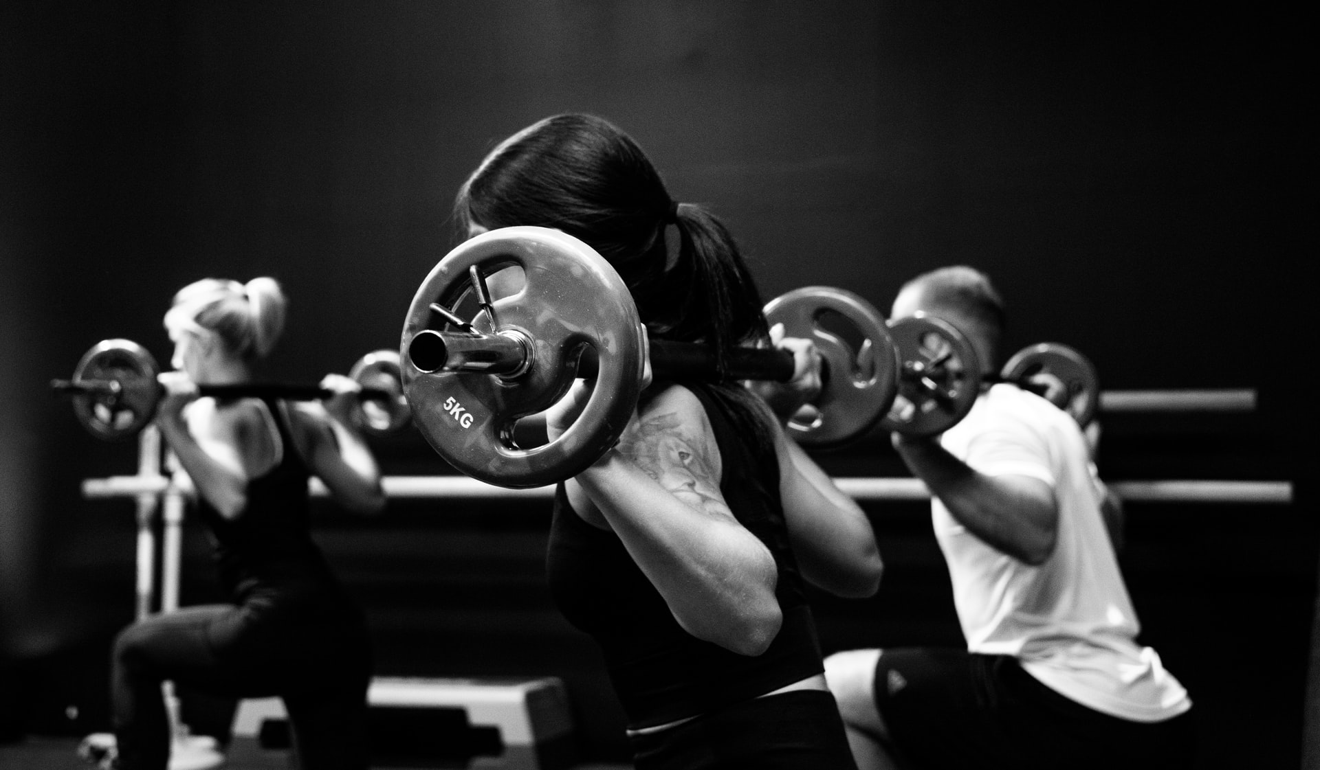 personas levantando pesas en un gimnasio